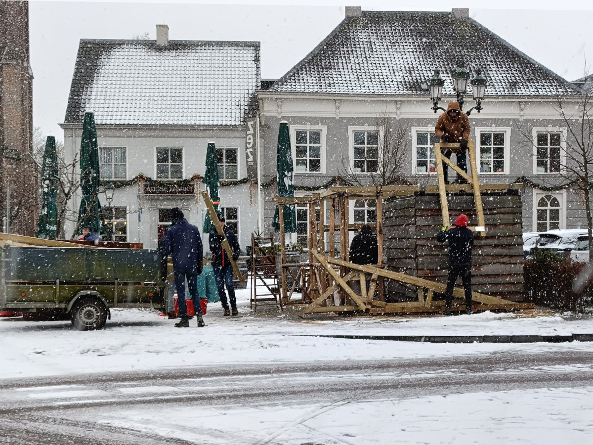 haagsemarkt met de vrijwiligers die de kerstal afbreken in de sneeuw